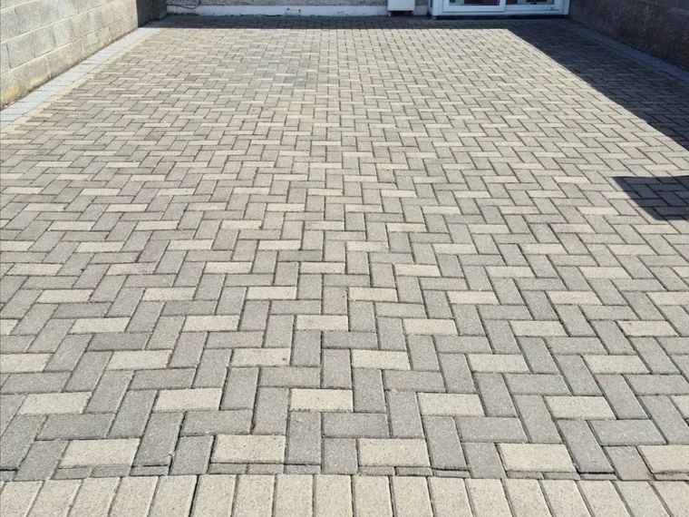 Freshly cleaned cobblelock driveway running up to a house.